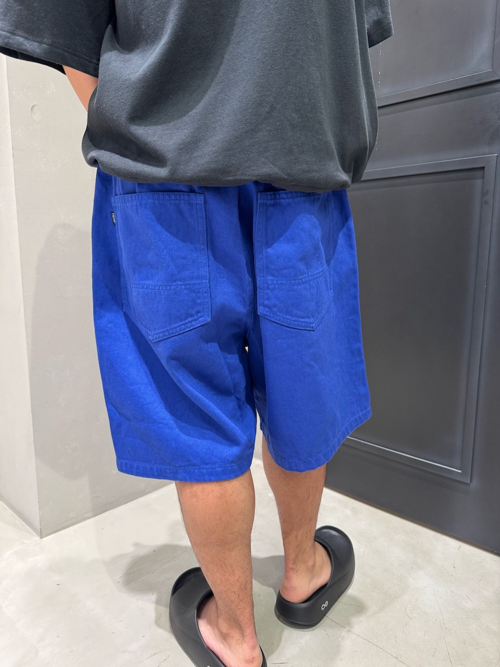 ブラック系のTシャツ/カットソー、ブルー系のその他パンツ、ブラック系のサンダルを着用したメンズの夏コーディネートの4枚目の写真
