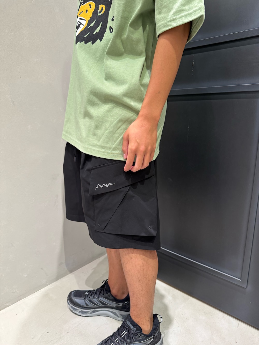 ブラック系のその他パンツ、ブラック系のスニーカー、グリーン系のTシャツ/カットソーを着用したメンズの夏コーディネートの5枚目の写真