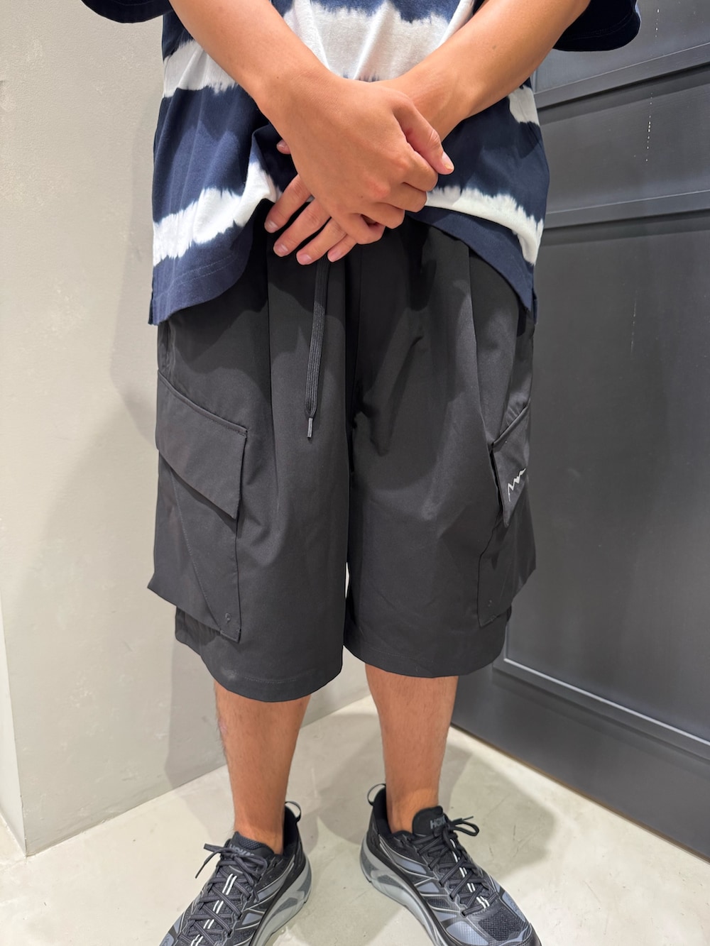 ブラック系のその他パンツ、ブラック系のスニーカー、ブルー系のTシャツ/カットソーを着用したメンズの夏コーディネートの3枚目の写真