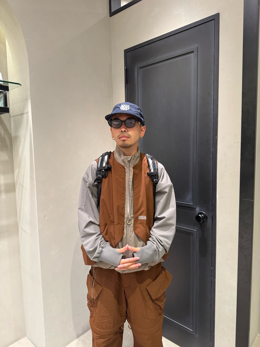 その他のベスト、ブラウン系のカーゴパンツ、ブラック系のサンダルを着用したメンズの秋コーディネートの2枚目の写真