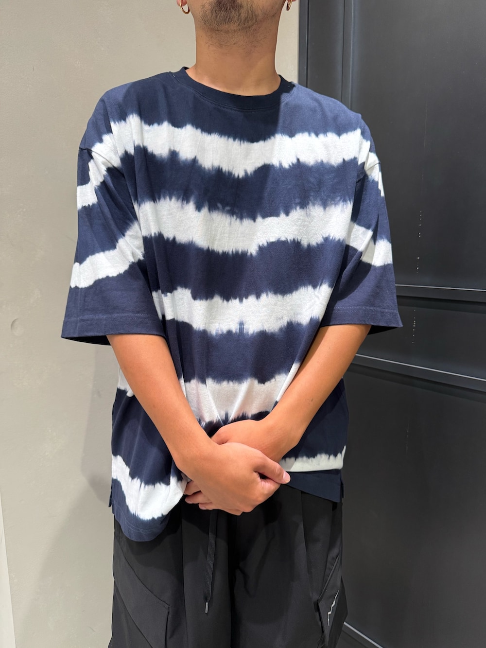 ブラック系のその他パンツ、ブラック系のスニーカー、ブルー系のTシャツ/カットソーを着用したメンズの夏コーディネートの2枚目の写真
