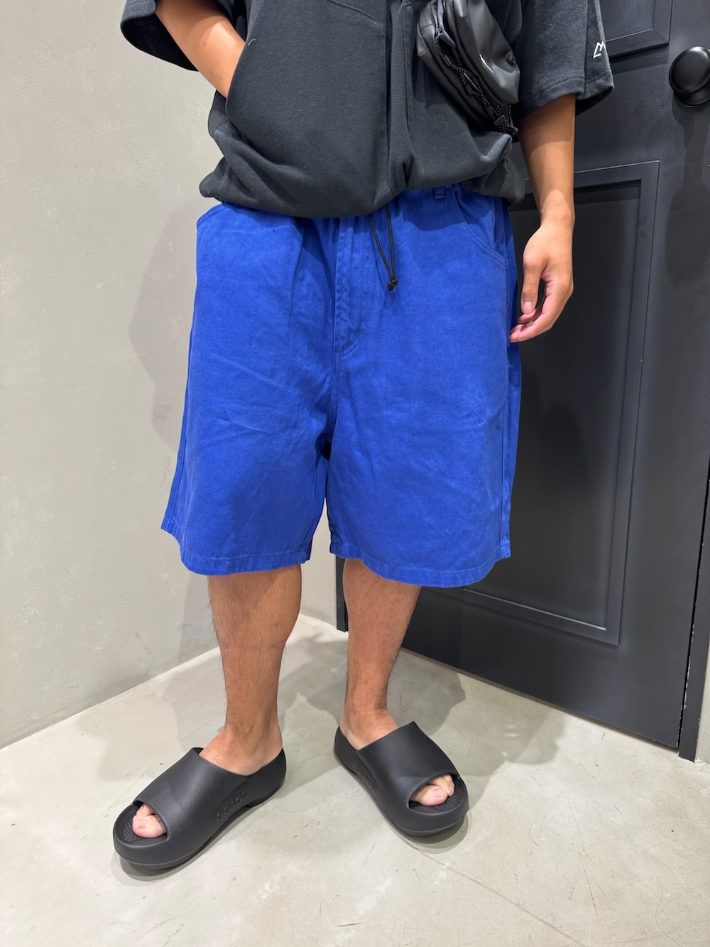 ブラック系のTシャツ/カットソー、ブルー系のその他パンツ、ブラック系のサンダルを着用したメンズの夏コーディネートの2枚目の写真