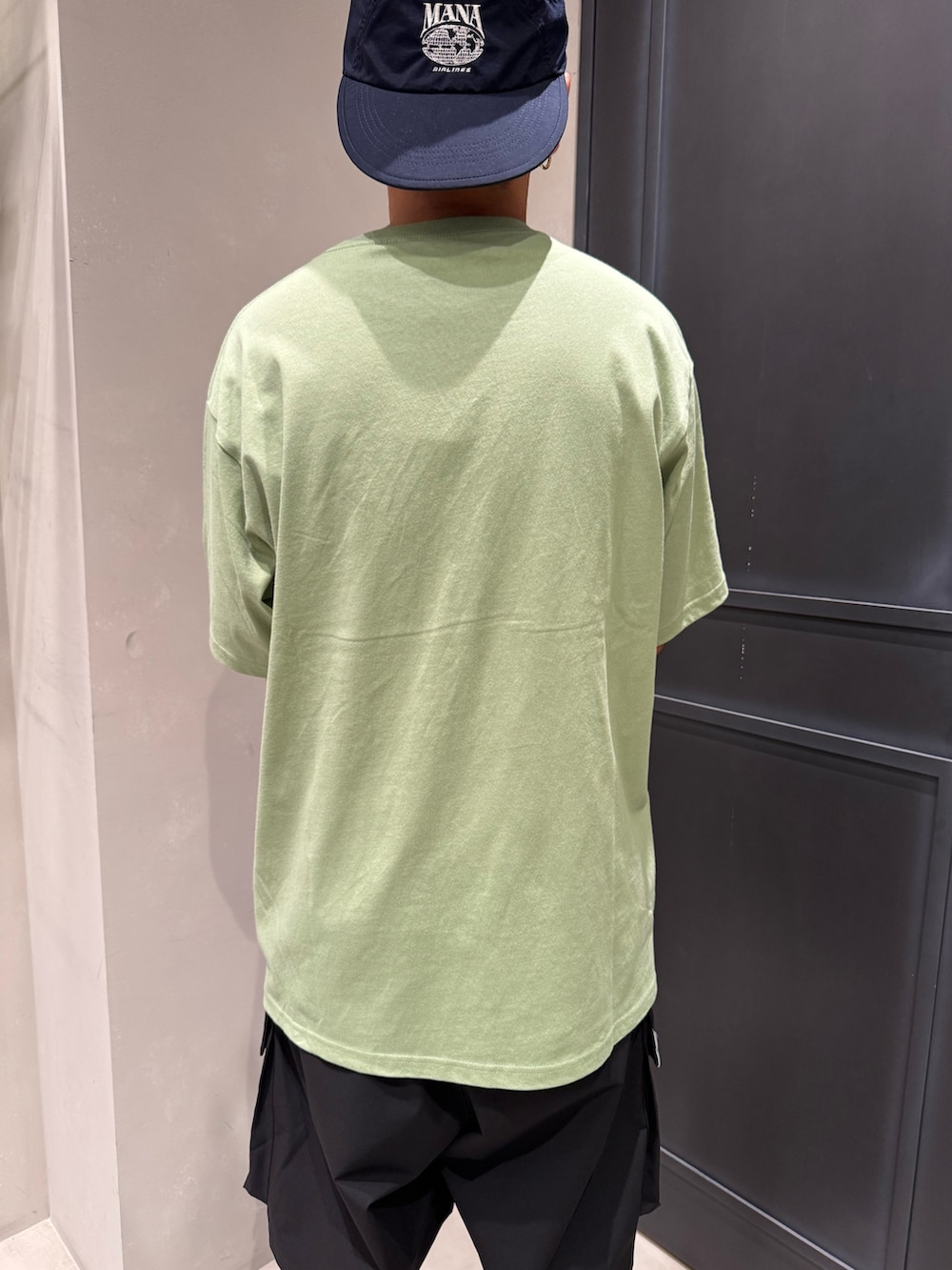 ブラック系のその他パンツ、ブラック系のスニーカー、グリーン系のTシャツ/カットソーを着用したメンズの夏コーディネートの4枚目の写真