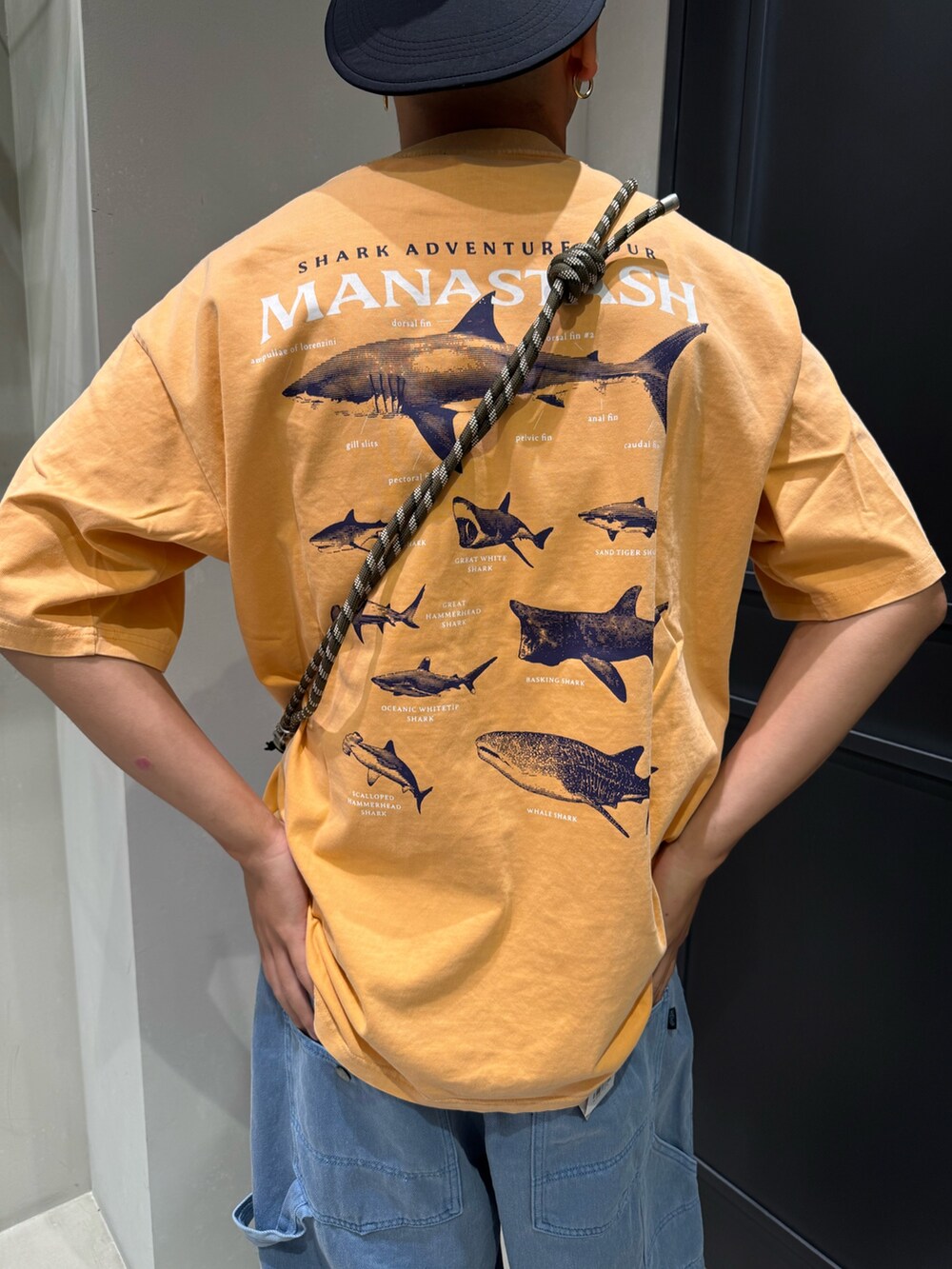 オレンジ系のTシャツ/カットソーを着用したメンズの夏コーディネートの5枚目の写真