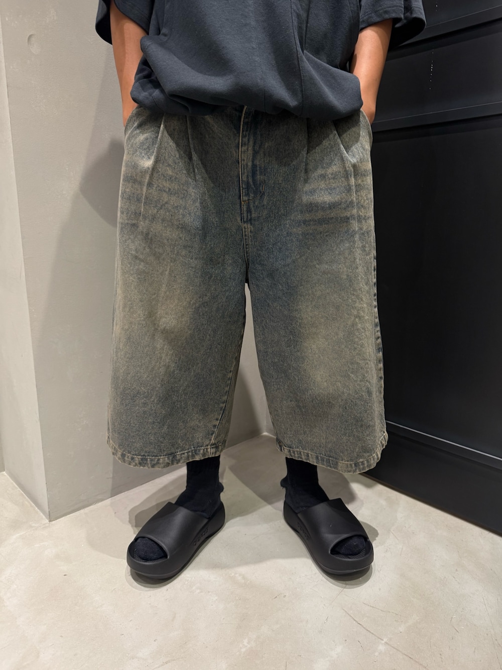 ブルー系のその他パンツ、ブラック系のTシャツ/カットソー、ブラック系のサンダルを着用したメンズの夏コーディネートの4枚目の写真