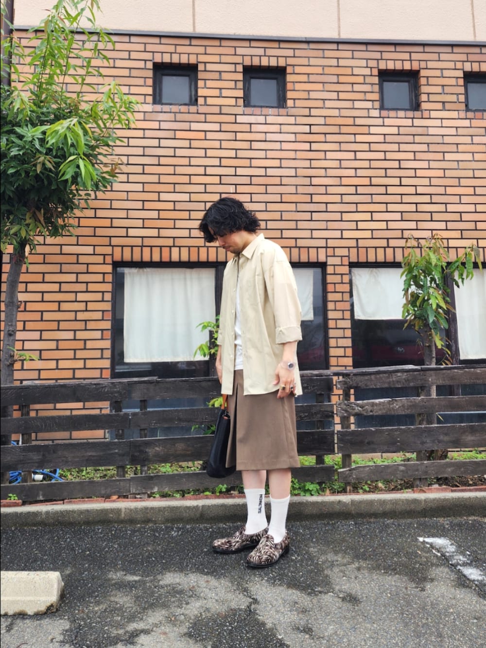 ブラウン系のその他パンツ、ブラック系のトートバッグ、ベージュ系のシャツ/ブラウスを着用したメンズの夏コーディネートの2枚目の写真