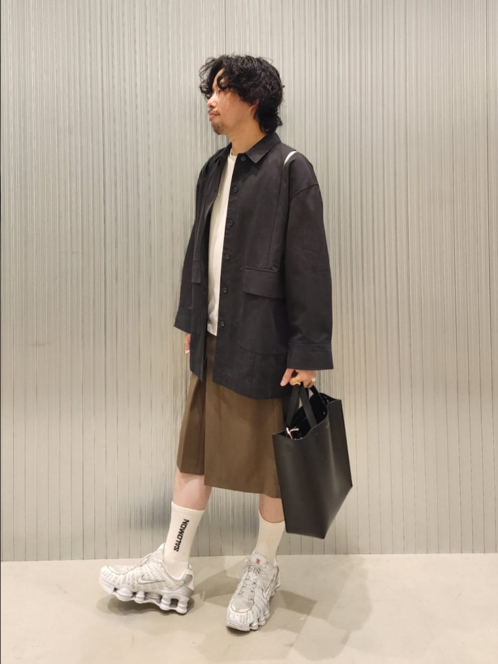 ブラック系のハンドバッグ、ブラウン系のその他パンツ、ブラック系のカバーオールを着用したメンズの夏コーディネートの3枚目の写真