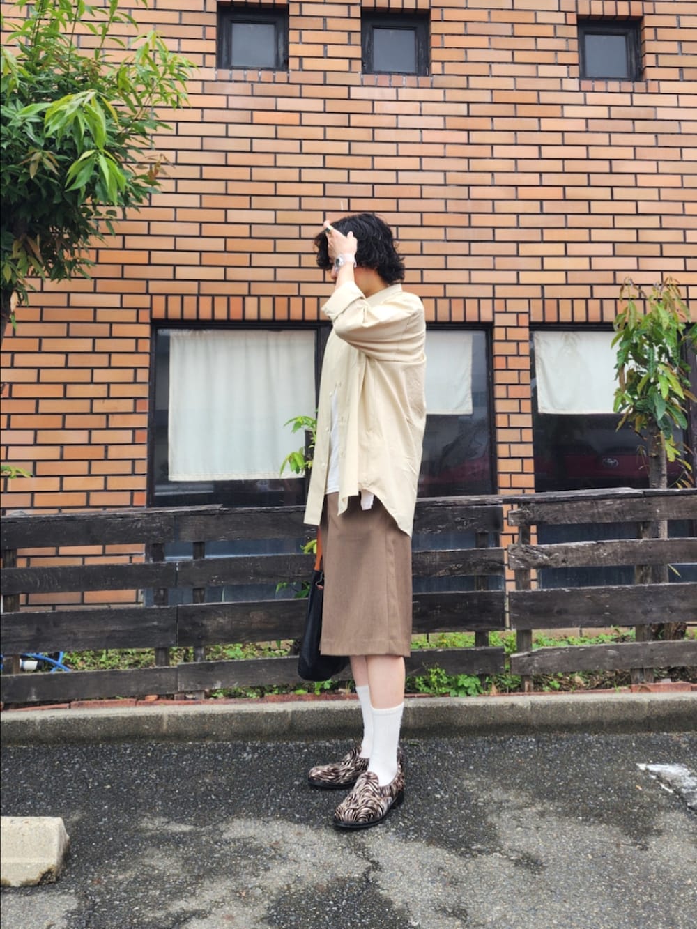 ブラウン系のその他パンツ、ブラック系のトートバッグ、ベージュ系のシャツ/ブラウスを着用したメンズの夏コーディネートの3枚目の写真