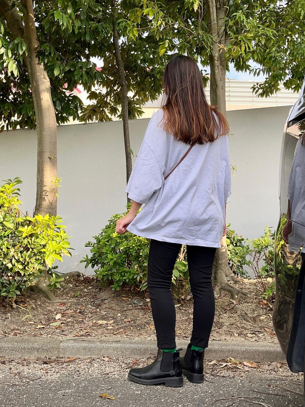グレー系のTシャツ/カットソー、ブラック系のパンツ、ブラック系のブーツを着用したレディースの秋コーディネートの2枚目の写真