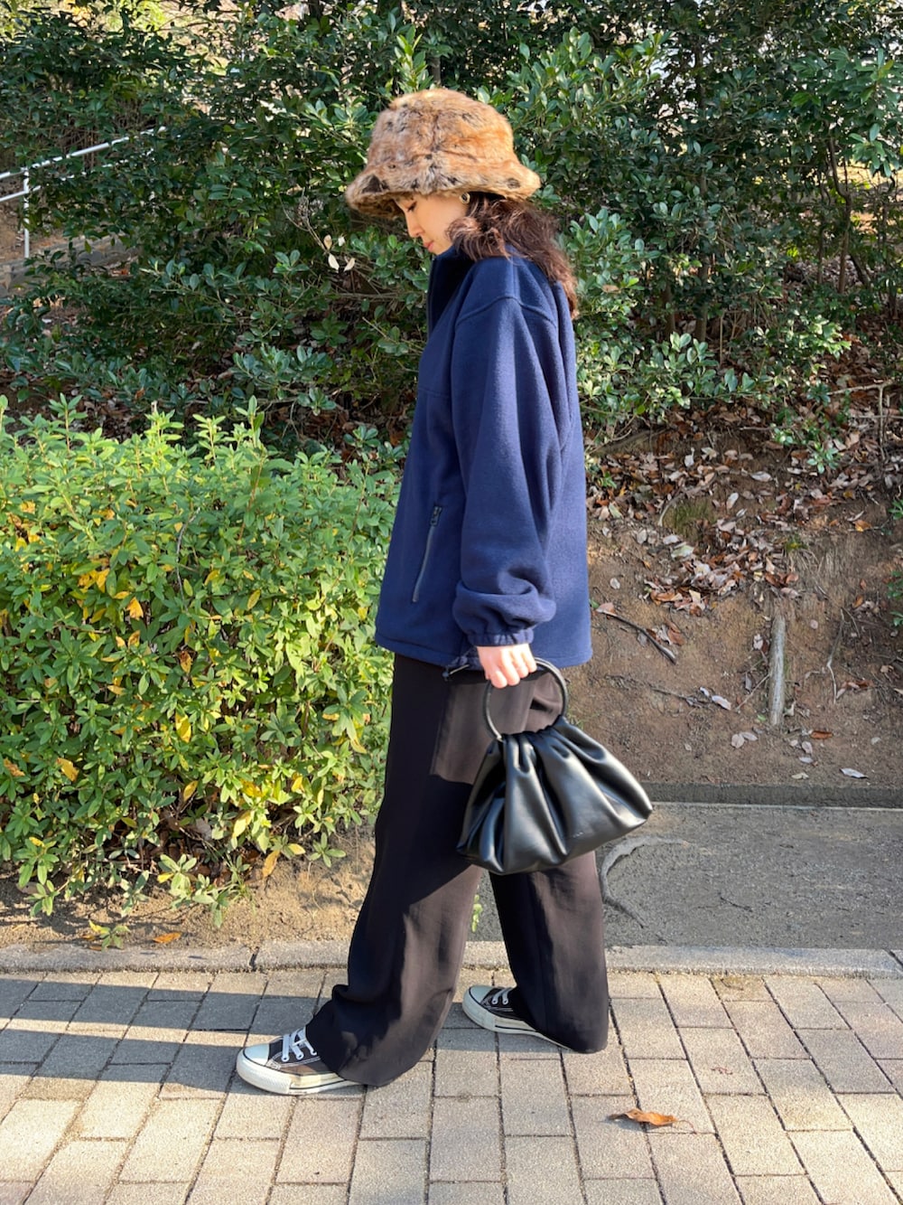 ブルー系のその他トップス、ブラック系のハンドバッグ、ブラック系のその他パンツを着用したレディースの冬コーディネートの2枚目の写真