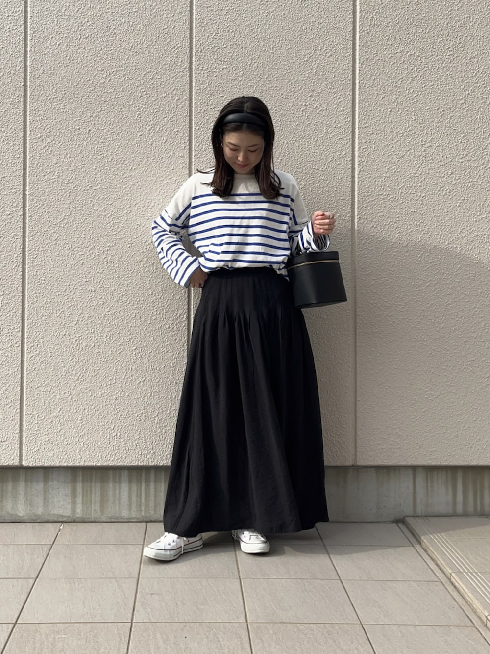 ブルー系のTシャツ/カットソー、ブラック系のショルダーバッグ、ブラック系のスカートを着用したレディースの春コーディネートの2枚目の写真