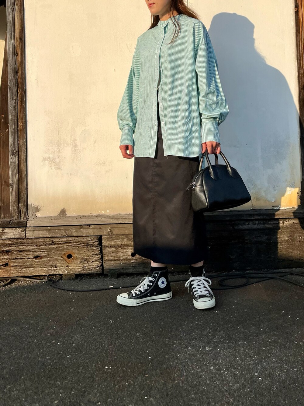 ブラック系のスニーカー、グリーン系のシャツ/ブラウス、ブラック系のスカートを着用したレディースの秋コーディネートの2枚目の写真