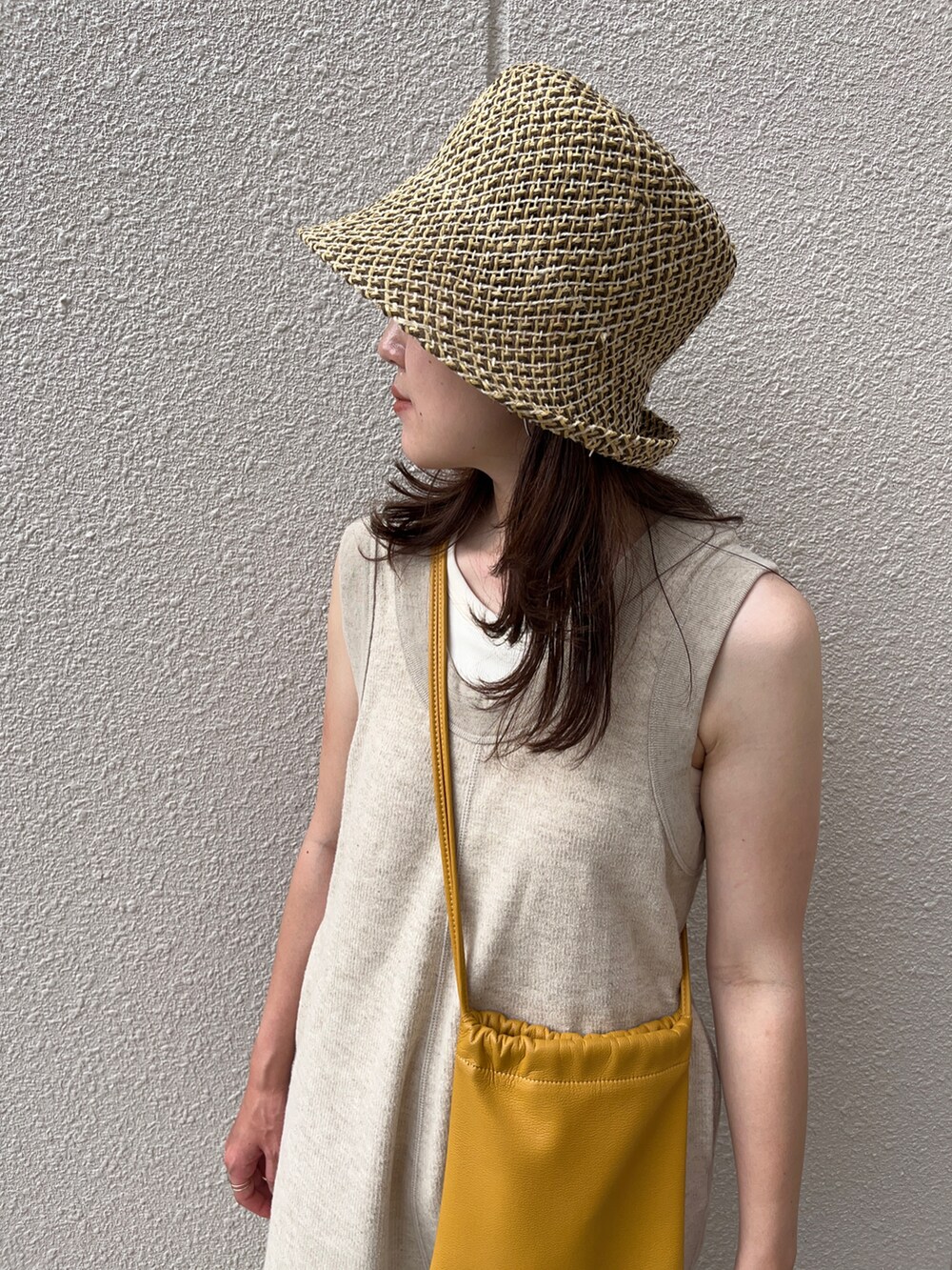 イエロー系のショルダーバッグ、ベージュ系のつなぎ/オールインワン、ベージュ系のサンダルを着用したレディースの夏コーディネートの3枚目の写真