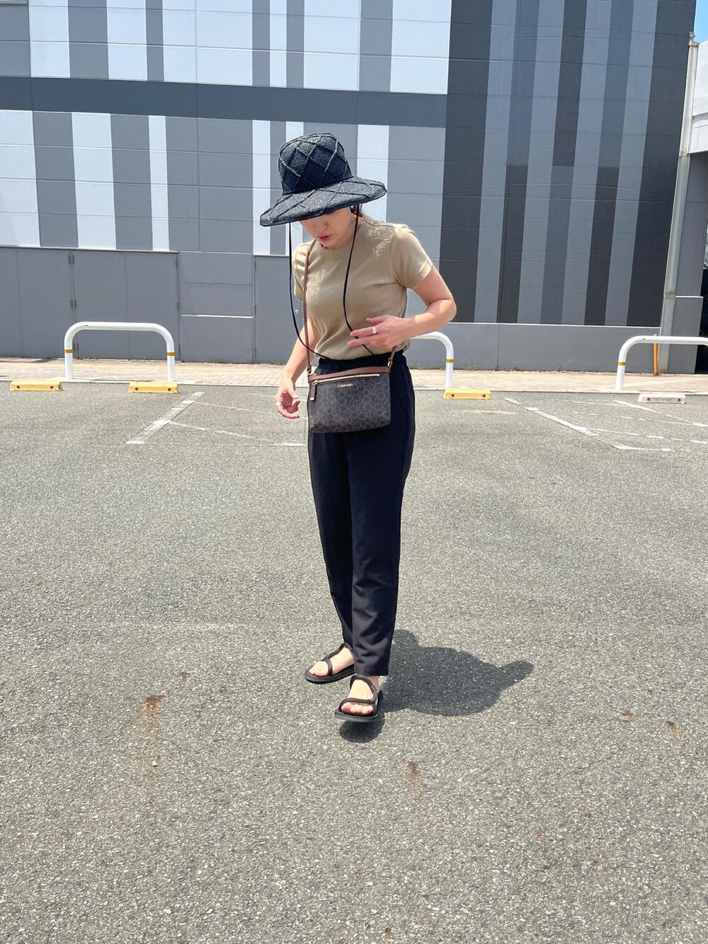 ブラック系のその他パンツ、ブラック系のサンダル、ブラック系のハットを着用したレディースの夏コーディネートの2枚目の写真