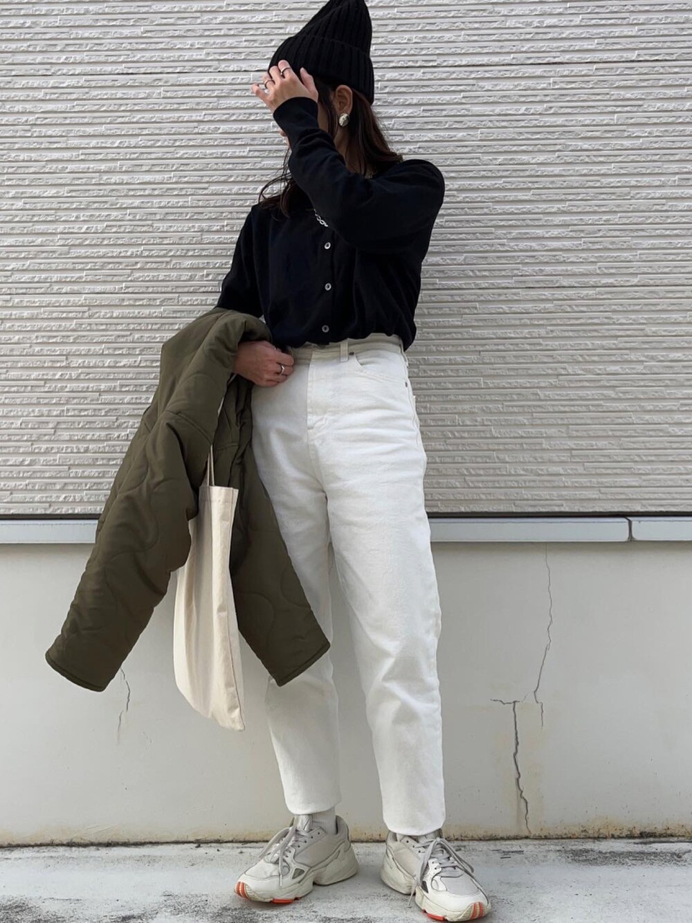 グリーン系のブルゾン、ブラック系のカーディガン/ボレロ、ホワイト系のその他パンツを着用したレディースの秋コーディネートの2枚目の写真