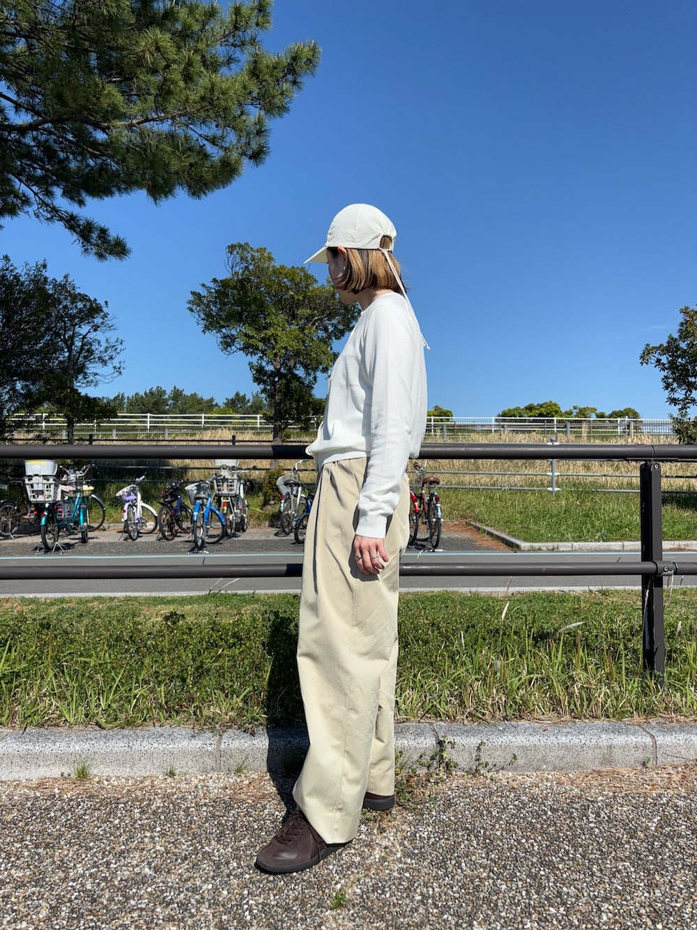 ベージュ系のその他パンツ、ブラウン系のスニーカー、ホワイト系のカーディガン/ボレロを着用したレディースの春コーディネートの2枚目の写真