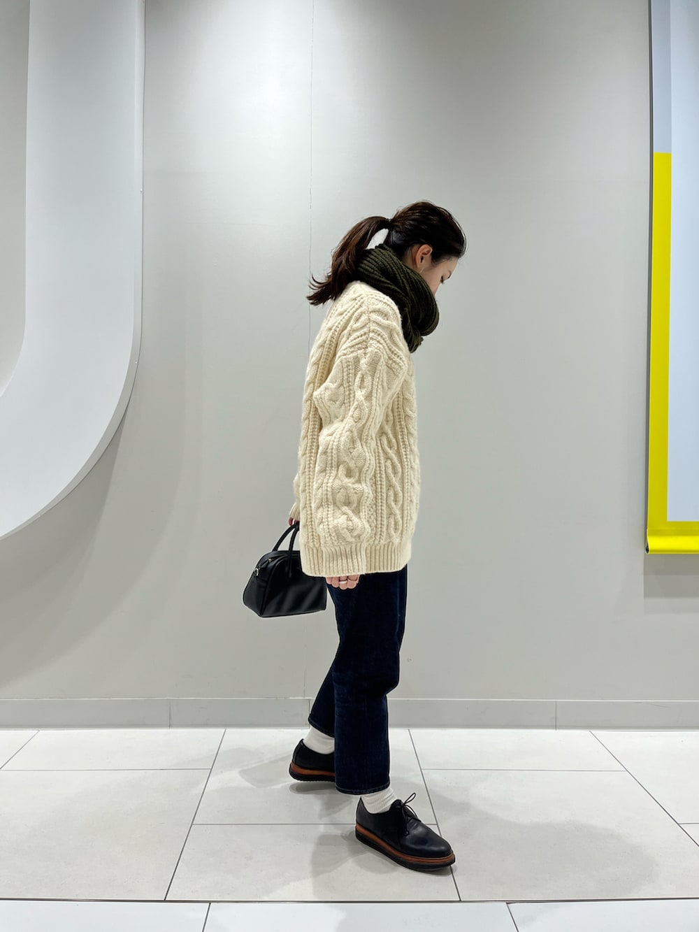 ホワイト系のニット/セーター、ブルー系のデニムパンツ、ブラック系のその他シューズを着用したレディースの冬コーディネートの2枚目の写真