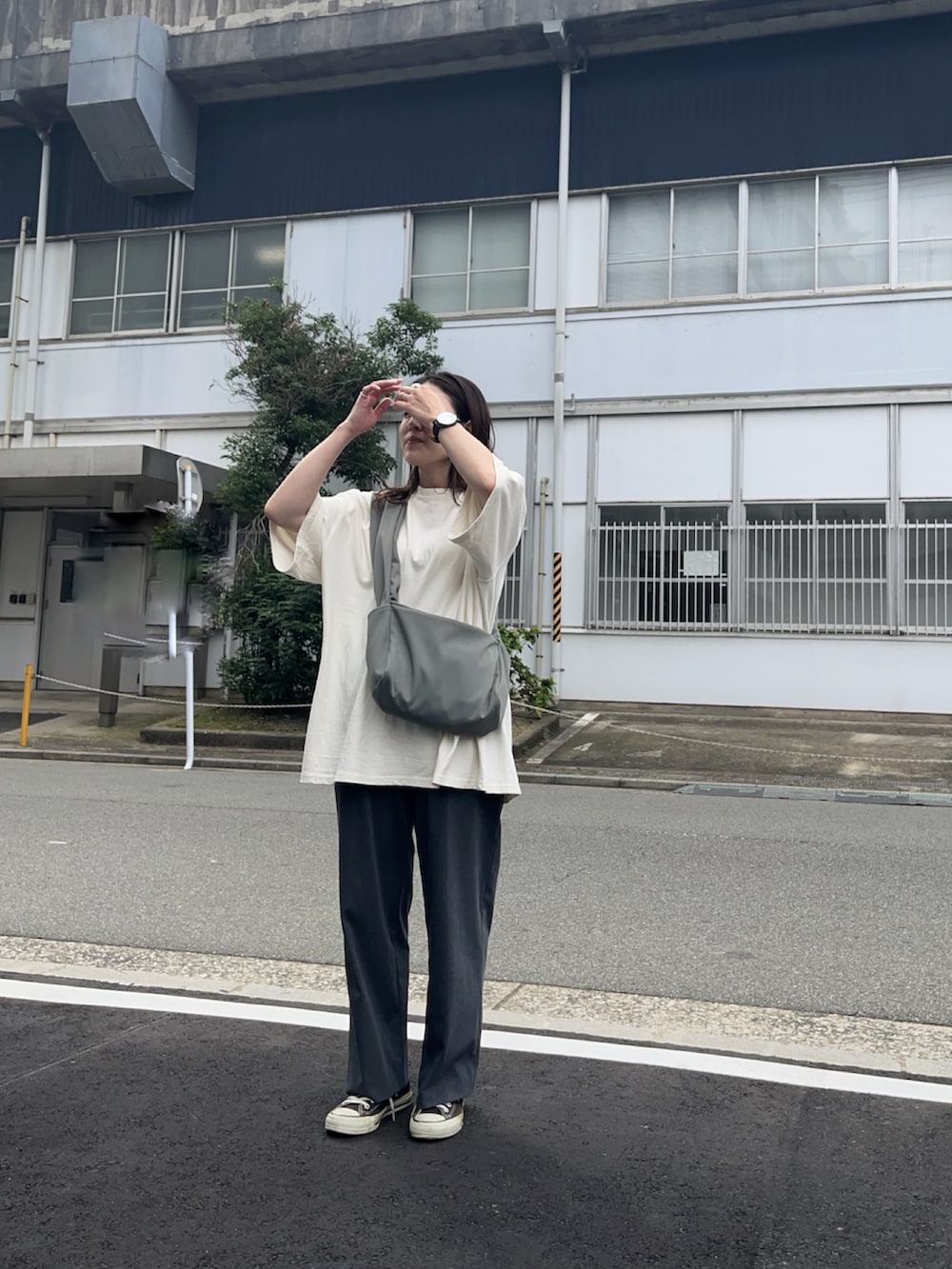 グレー系のショルダーバッグ、グレー系のパンツ、ベージュ系のTシャツ/カットソーを着用したレディースの秋コーディネートの2枚目の写真