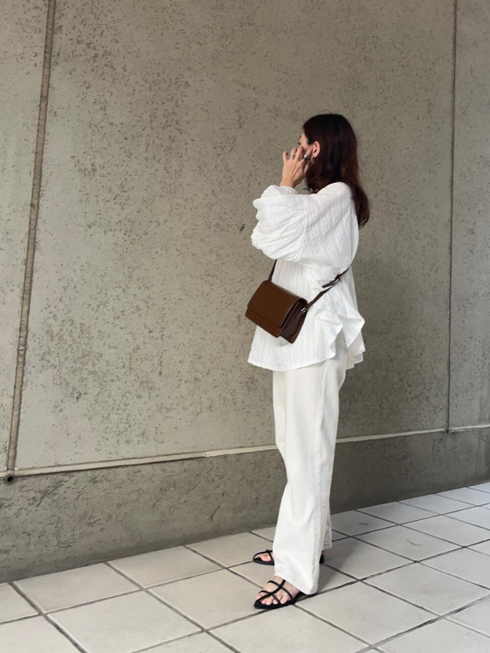 ブラウン系のショルダーバッグ、ホワイト系のシャツ/ブラウスを着用したレディースの秋コーディネートの2枚目の写真