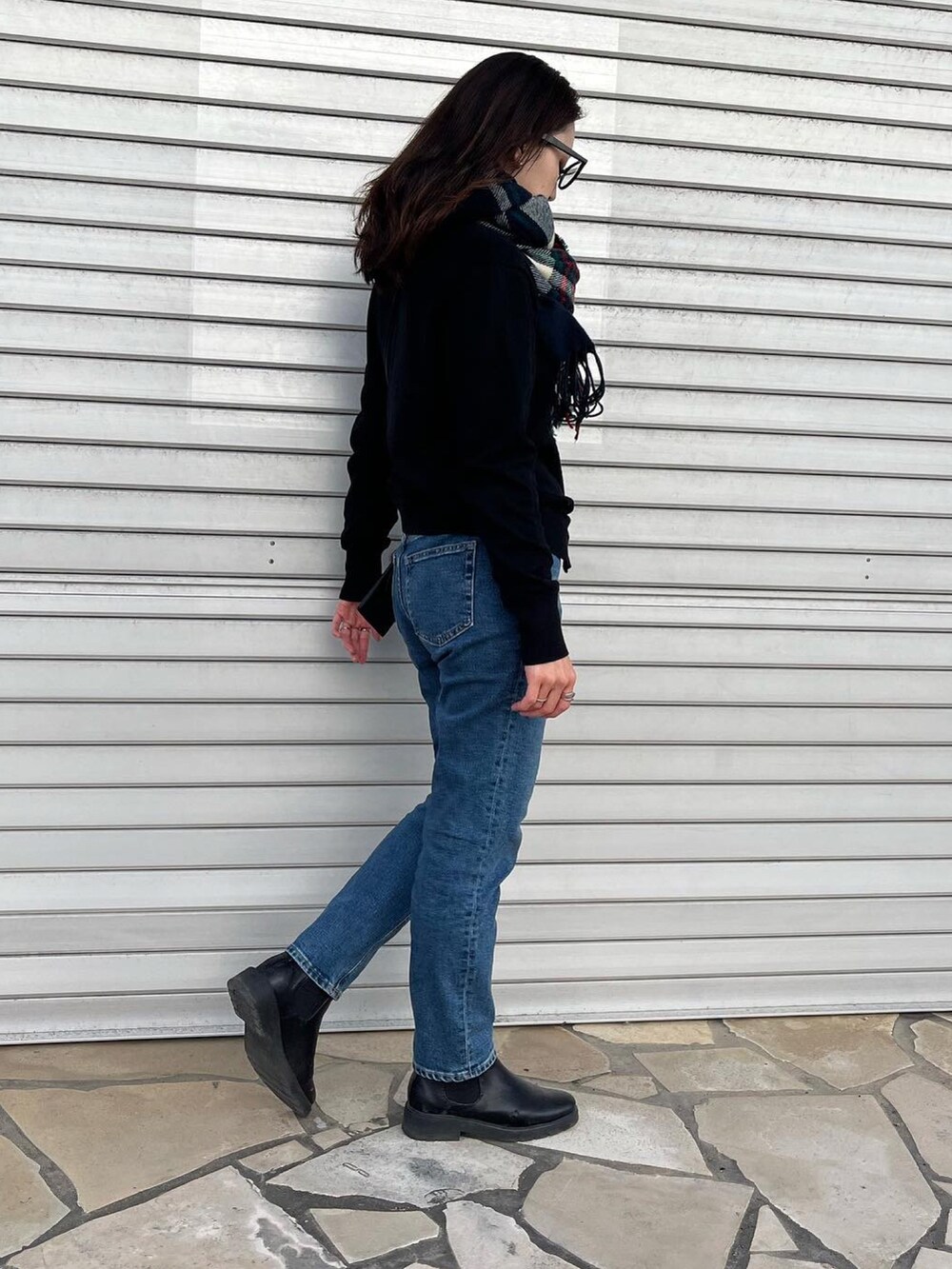 ブルー系のデニムパンツ、ブラック系のカーディガン/ボレロ、ブラック系のショルダーバッグを着用したレディースの冬コーディネートの2枚目の写真