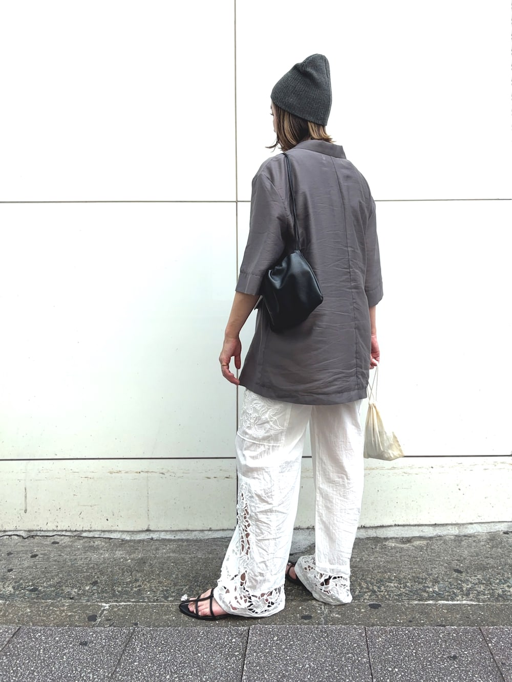 ホワイト系のその他パンツ、グレー系のその他アウター、ブラック系のハンドバッグを着用したレディースの夏コーディネートの2枚目の写真