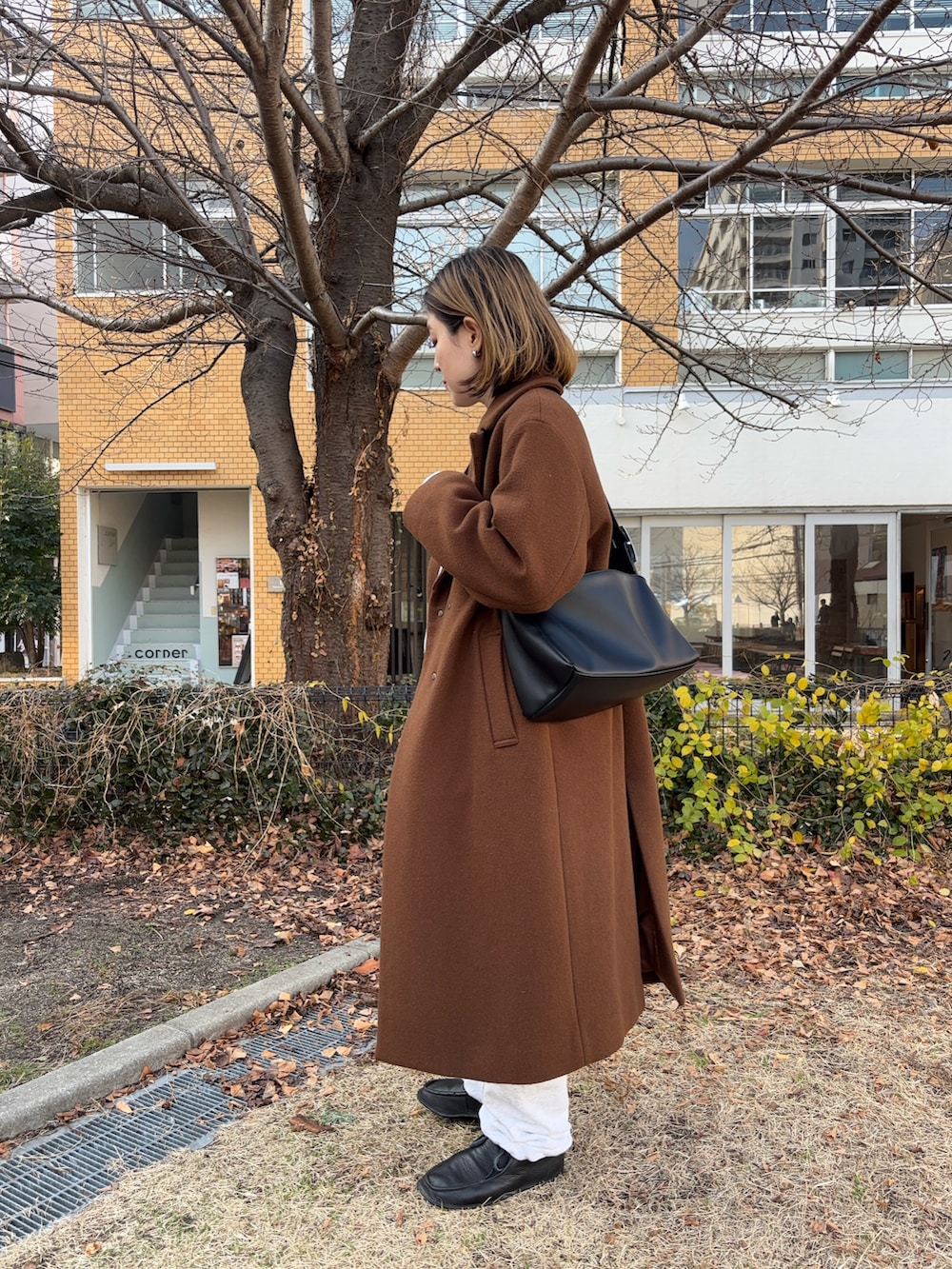 ブラック系のショルダーバッグ、ブラック系のモカシン/デッキシューズ、その他のスウェットを着用したレディースの冬コーディネートの2枚目の写真