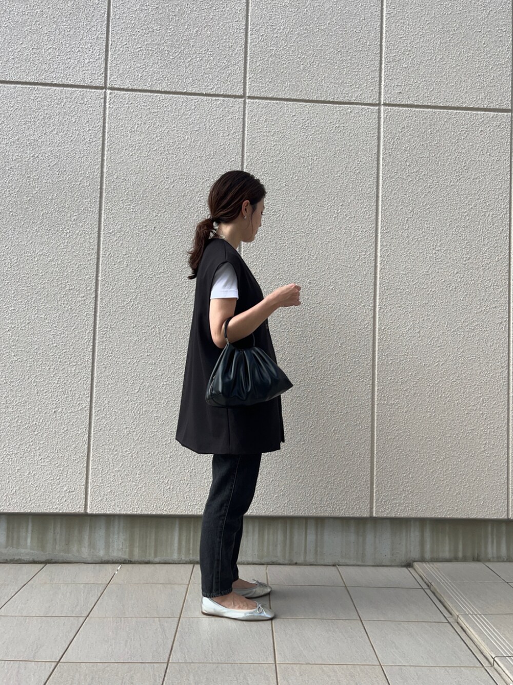 ブラック系のデニムパンツ、ホワイト系のTシャツ/カットソー、シルバー系のバレエシューズを着用したレディースの秋コーディネートの2枚目の写真