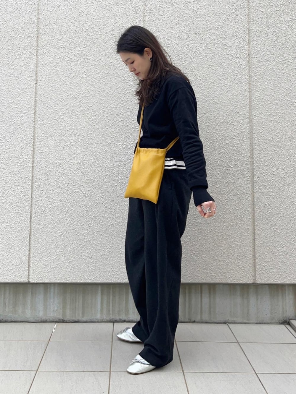 ブラック系のカーディガン/ボレロ、イエロー系のショルダーバッグ、グレー系のパンツを着用したレディースの冬コーディネートの3枚目の写真