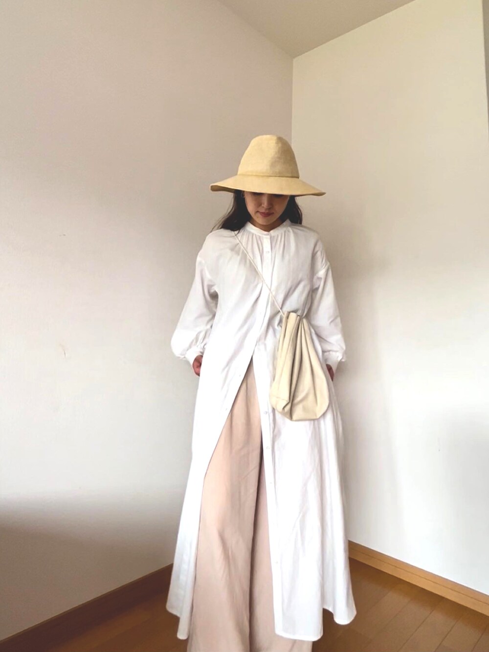 ホワイト系のシャツワンピース、ホワイト系のハンドバッグ、ベージュ系のその他パンツを着用したレディースの秋コーディネートの2枚目の写真