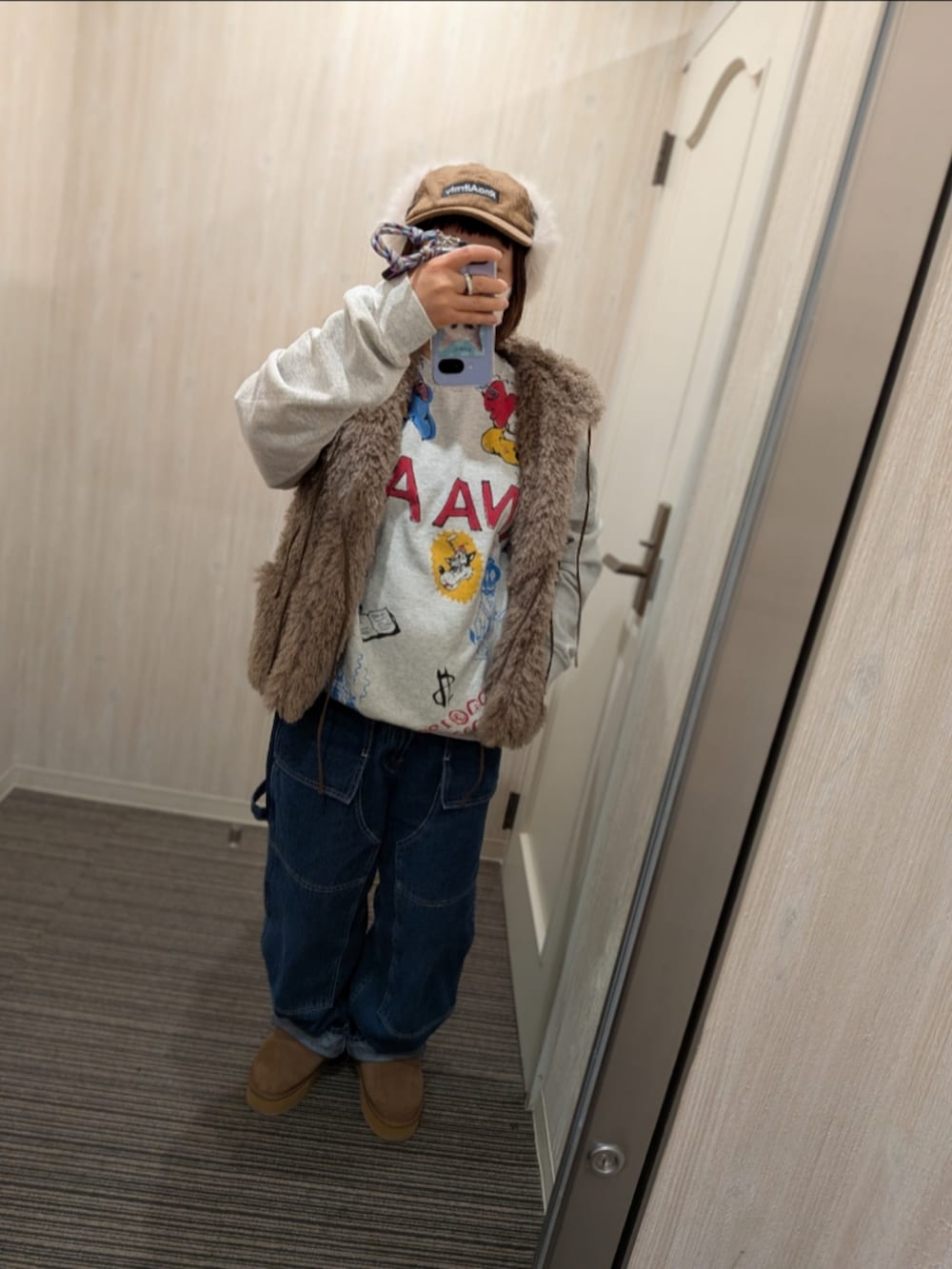 ブラック系のメッセンジャーバッグ、ブルー系のデニムパンツ、ブラウン系のブーツを着用したレディースの冬コーディネートの2枚目の写真