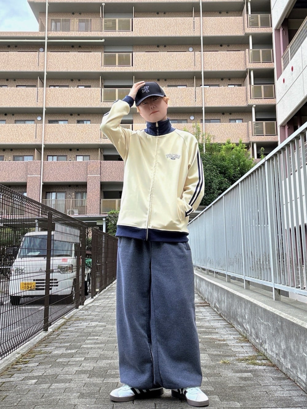 ホワイト系のスニーカー、ホワイト系のブルゾン、グレー系のスウェットパンツを着用したメンズの秋コーディネートの2枚目の写真