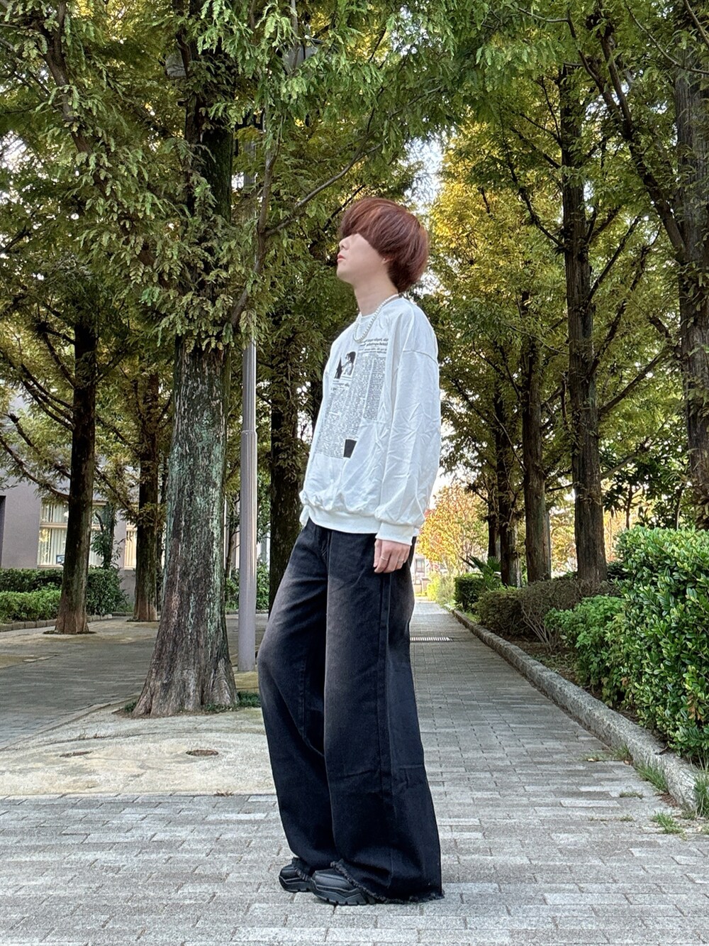 ホワイト系のスウェット、ブラック系のデニムパンツ、ブラック系のスニーカーを着用したメンズの秋コーディネートの2枚目の写真