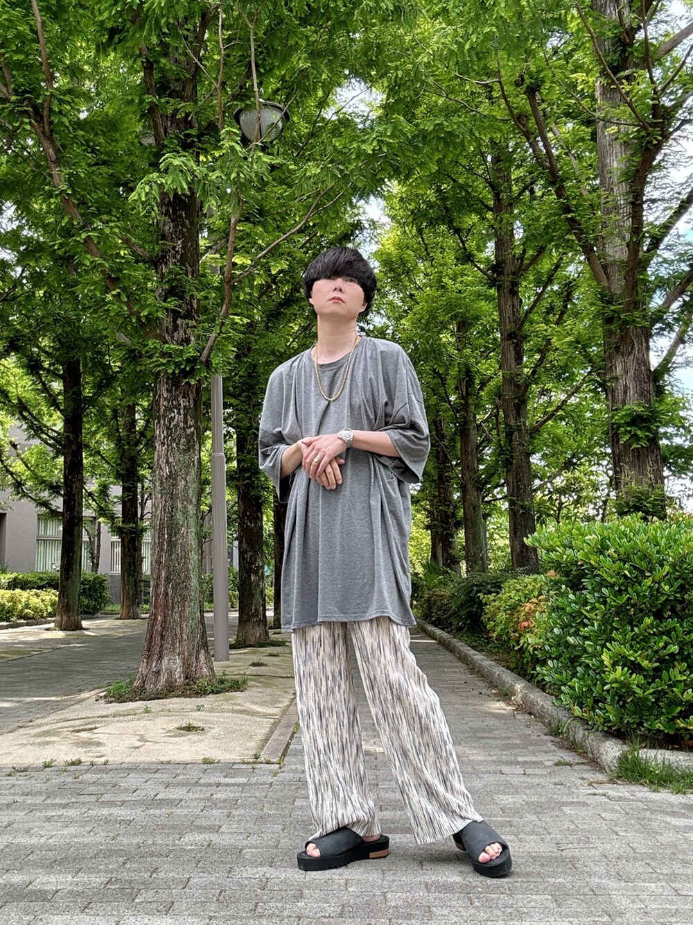 グレー系のTシャツ/カットソー、ホワイト系のその他パンツ、ブラック系のサンダルを着用したメンズの夏コーディネートの2枚目の写真