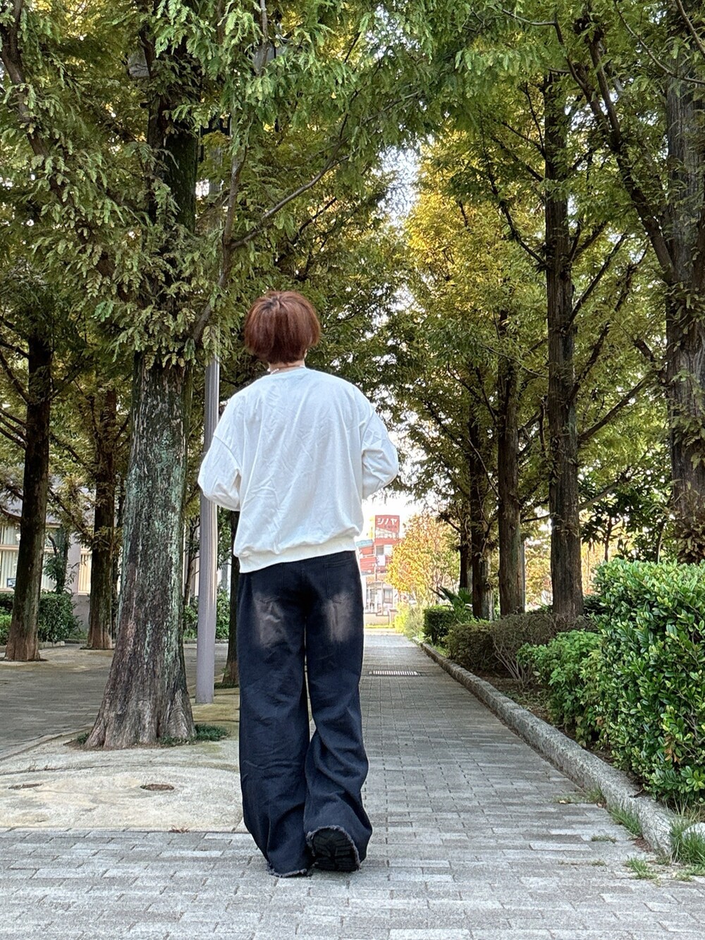 ホワイト系のスウェット、ブラック系のデニムパンツ、ブラック系のスニーカーを着用したメンズの秋コーディネートの3枚目の写真