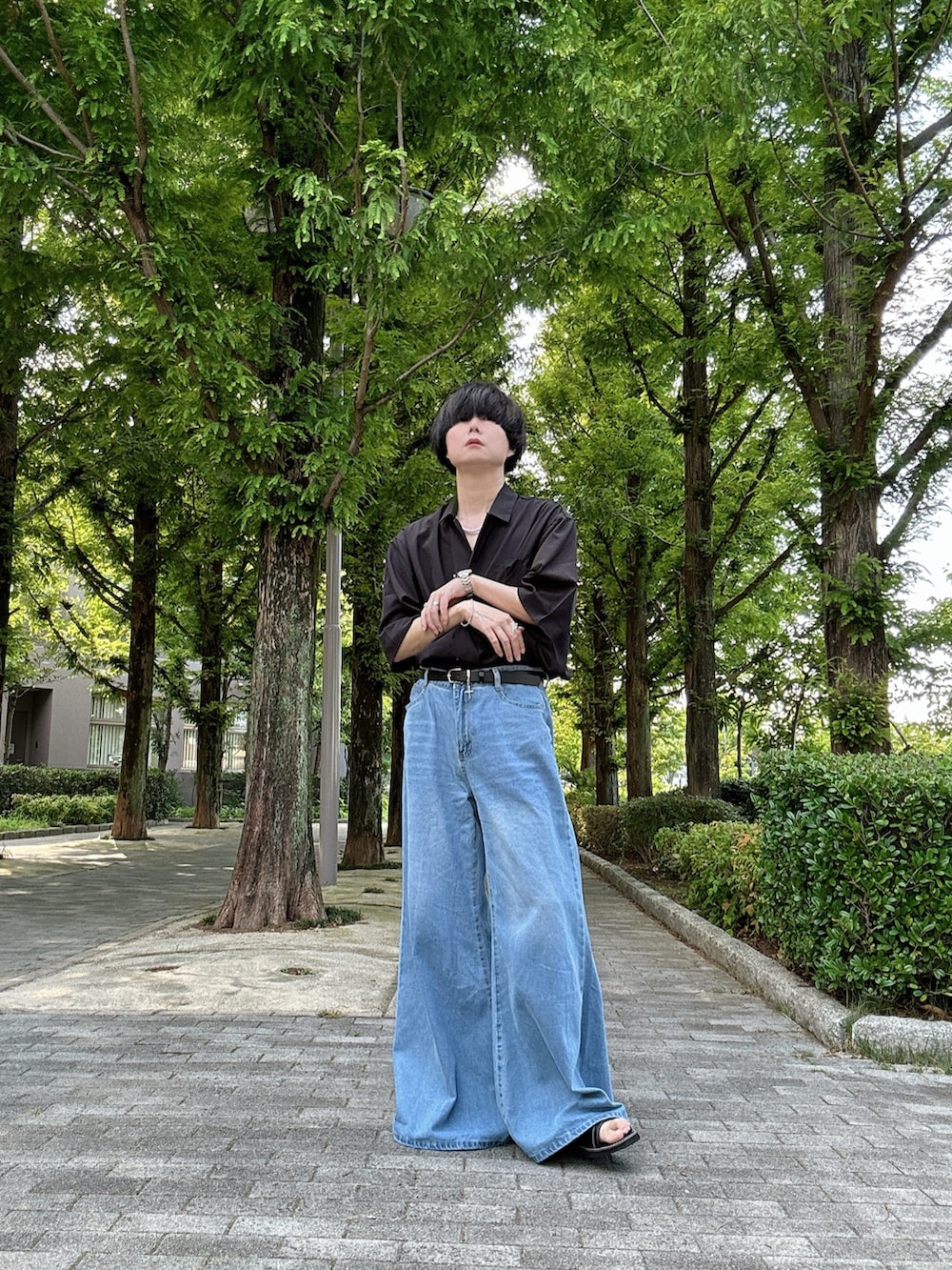 ブラック系のシャツ/ブラウス、ブルー系のデニムパンツ、ブラック系のサンダルを着用したメンズの夏コーディネートの2枚目の写真