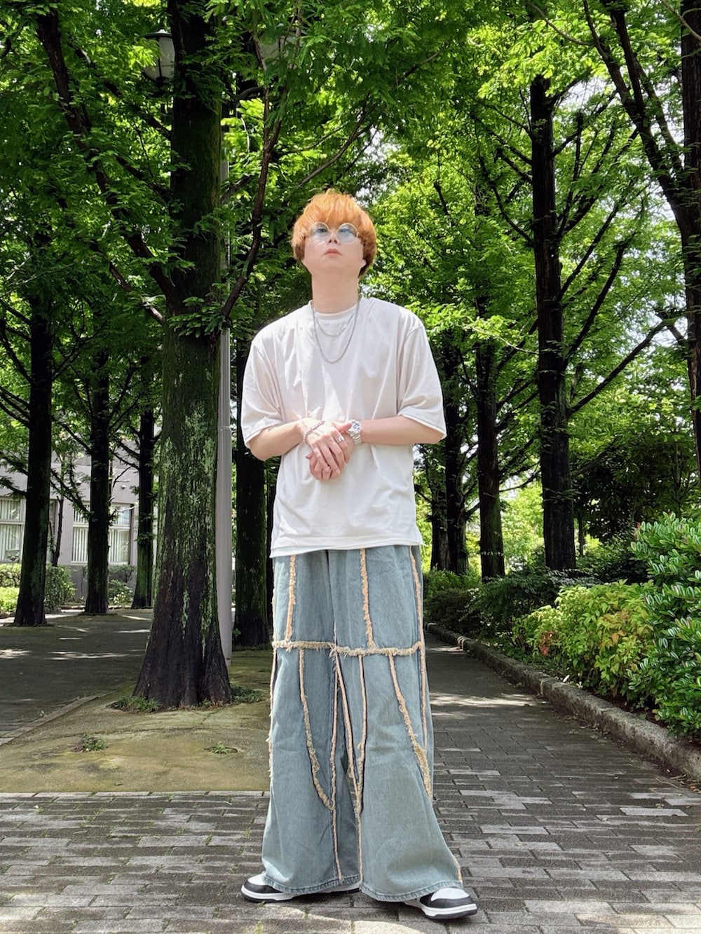 ホワイト系のTシャツ/カットソー、ホワイト系のスニーカー、ブルー系のデニムパンツを着用したメンズの夏コーディネートの2枚目の写真