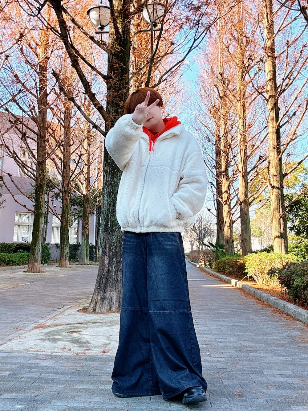 ホワイト系のブルゾン、オレンジ系のパーカー、ブラック系のデニムパンツを着用したメンズの冬コーディネートの3枚目の写真