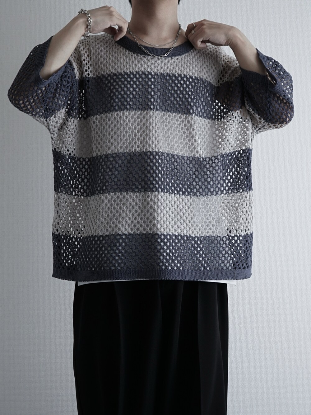 ホワイト系のタンクトップ、ブルー系のデニムパンツ、ブラック系のサンダルを着用したメンズの夏コーディネートの2枚目の写真