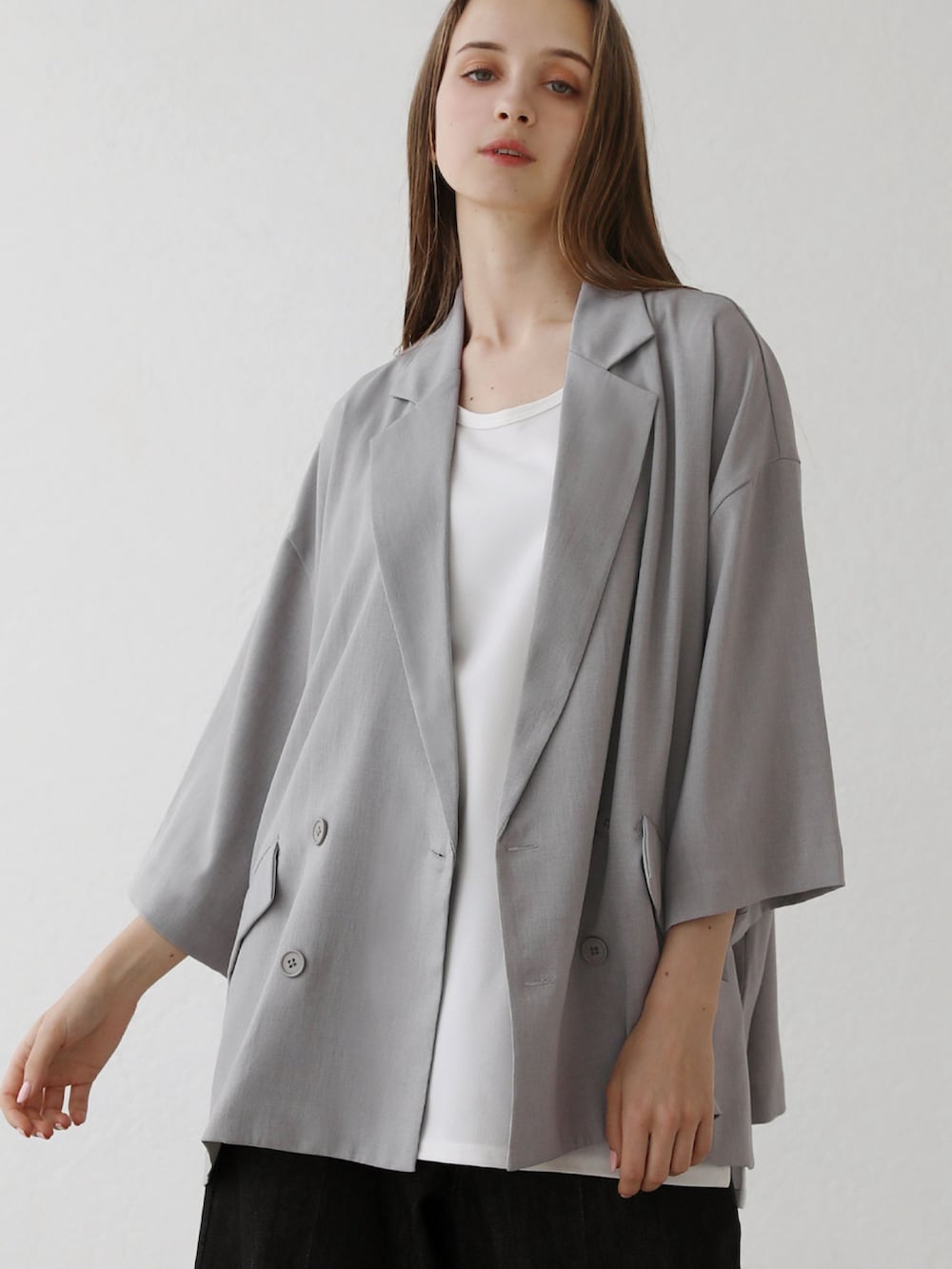 グレー系のテーラードジャケット、ホワイト系のタンクトップ、グレー系のデニムパンツを着用したメンズの夏コーディネートの3枚目の写真