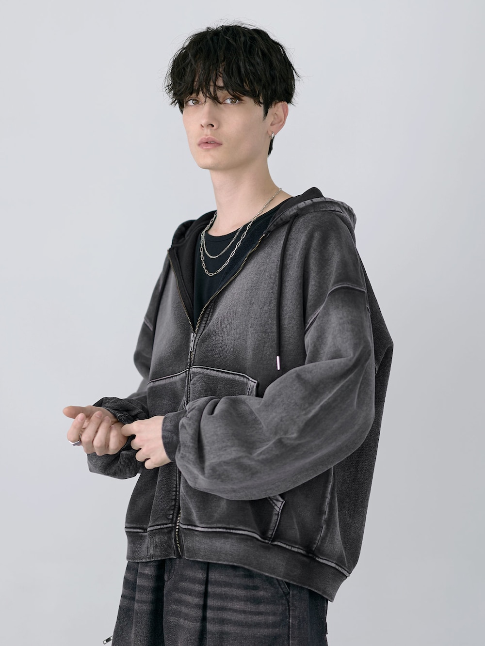 ブラック系のカーゴパンツ、グレー系のパーカー、ブラック系のショルダーバッグを着用したメンズの冬コーディネートの3枚目の写真