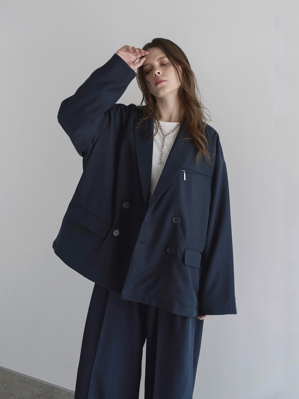 ホワイト系のTシャツ/カットソー、ブルー系のスラックス、ブラック系のショルダーバッグを着用したメンズの秋コーディネートの2枚目の写真
