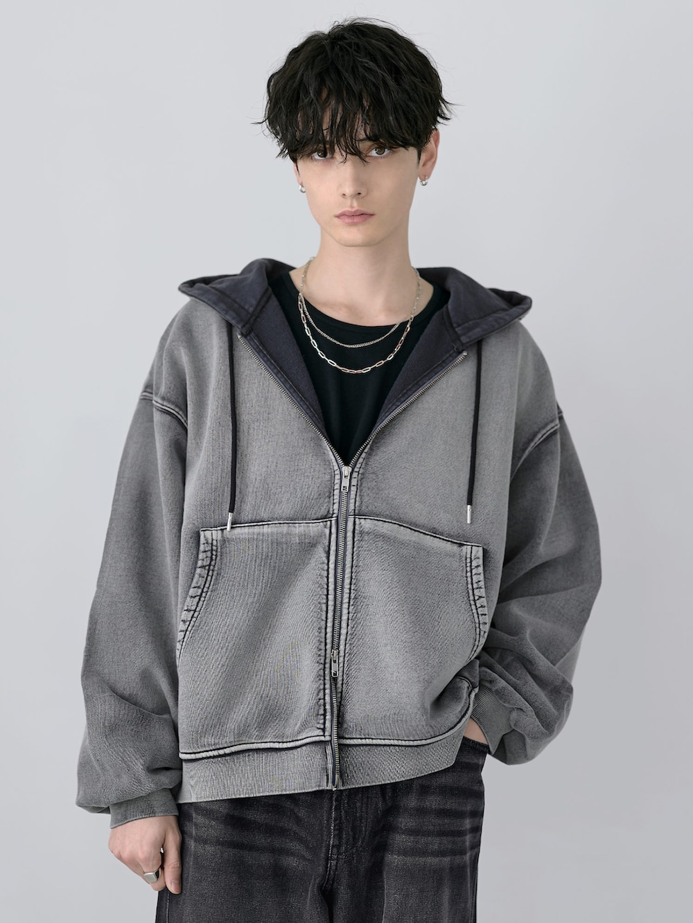 グレー系のパーカー、その他のスラックス、ブラック系のショルダーバッグを着用したメンズの冬コーディネートの2枚目の写真