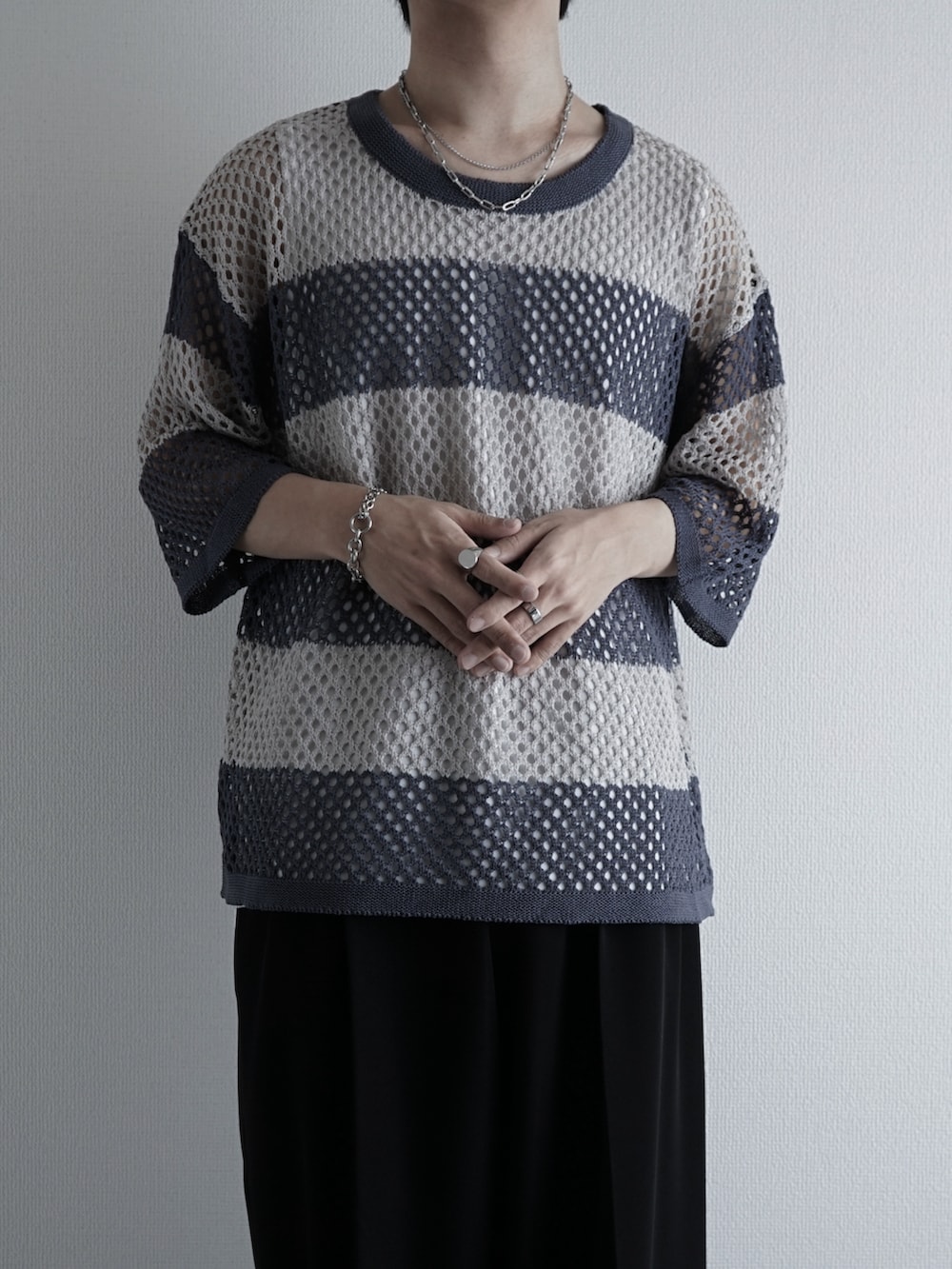 ホワイト系のタンクトップ、ブルー系のデニムパンツ、ブラック系のサンダルを着用したメンズの夏コーディネートの3枚目の写真