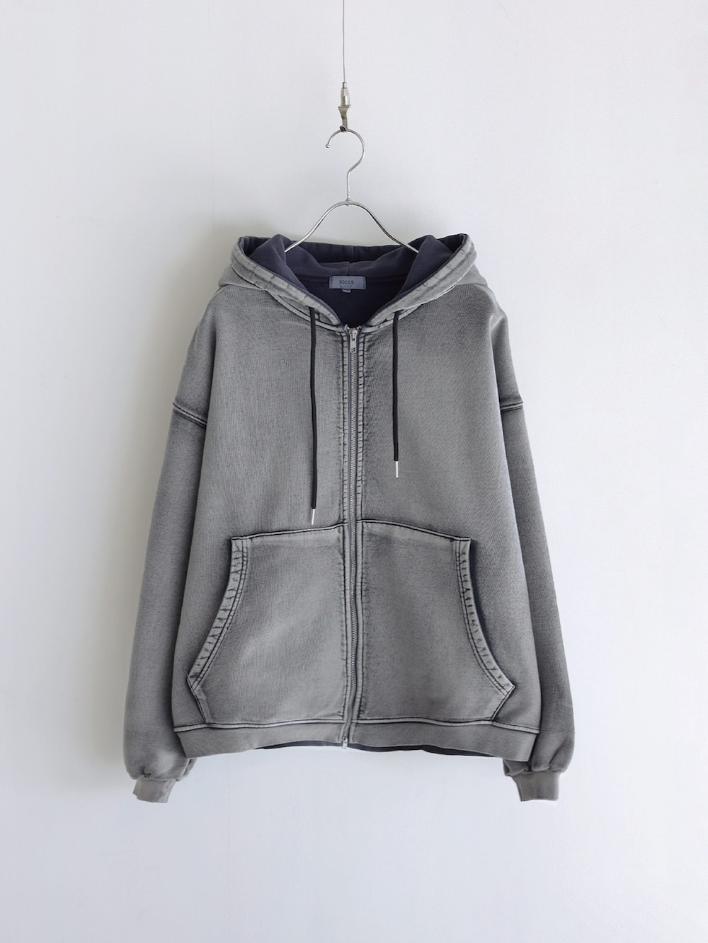 グレー系のパーカー、その他のスラックス、ブラック系のショルダーバッグを着用したメンズの冬コーディネートの4枚目の写真