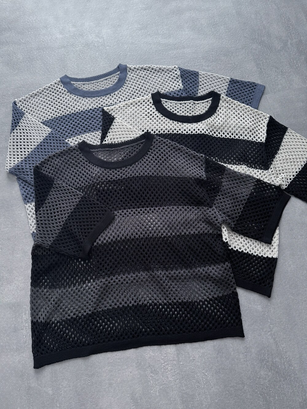 ホワイト系のタンクトップ、ブルー系のデニムパンツ、ブラック系のサンダルを着用したメンズの夏コーディネートの4枚目の写真