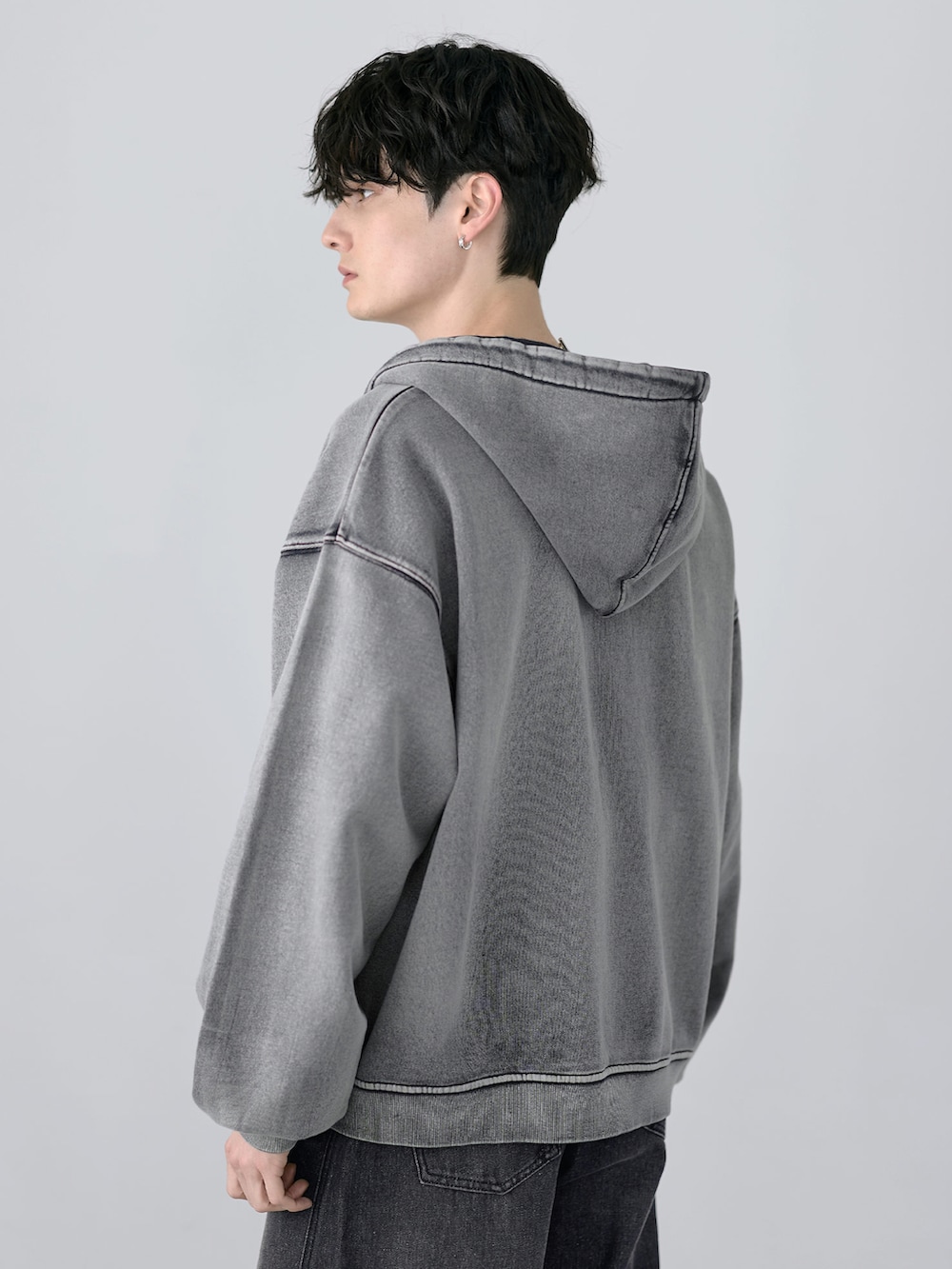 グレー系のパーカー、その他のスラックス、ブラック系のショルダーバッグを着用したメンズの冬コーディネートの3枚目の写真