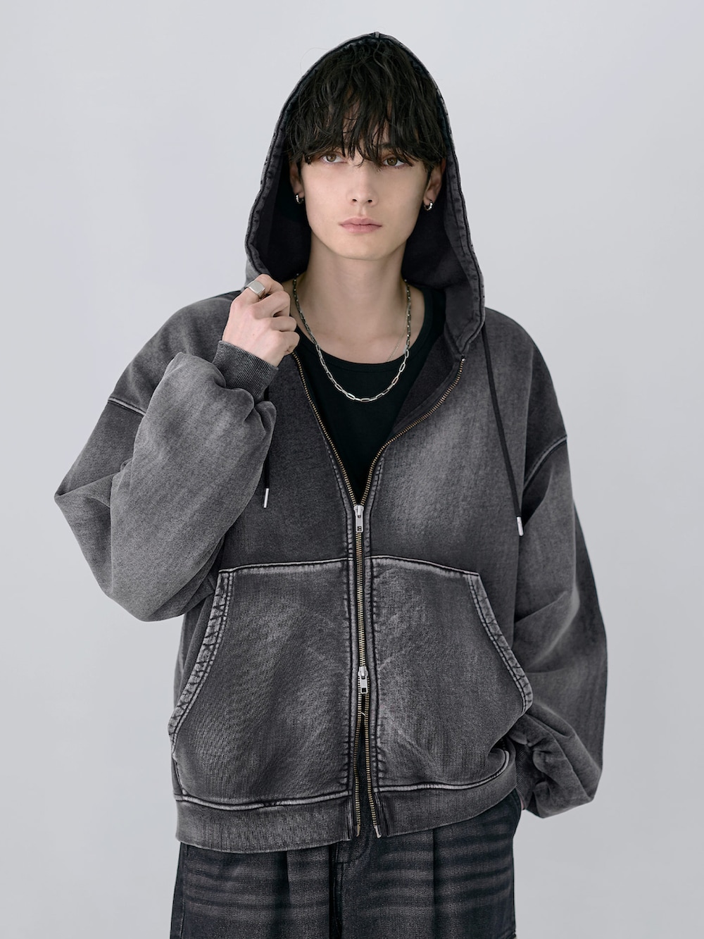 ブラック系のカーゴパンツ、グレー系のパーカー、ブラック系のショルダーバッグを着用したメンズの冬コーディネートの2枚目の写真