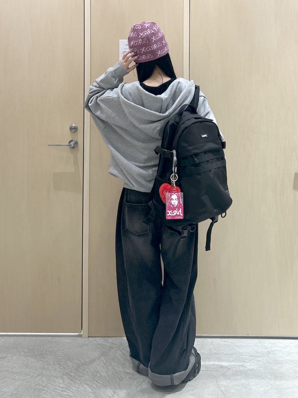 グレー系のパーカー、ブラック系のデニムパンツ、ブラック系のバックパック/リュックを着用したレディースの冬コーディネートの3枚目の写真