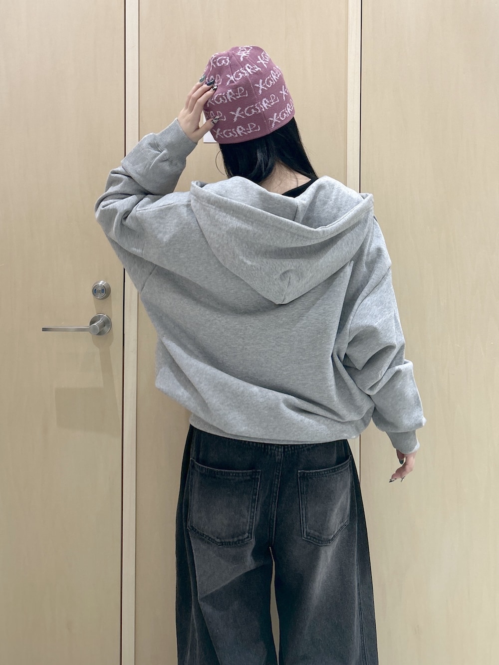 グレー系のパーカー、ブラック系のデニムパンツ、ブラック系のバックパック/リュックを着用したレディースの冬コーディネートの6枚目の写真