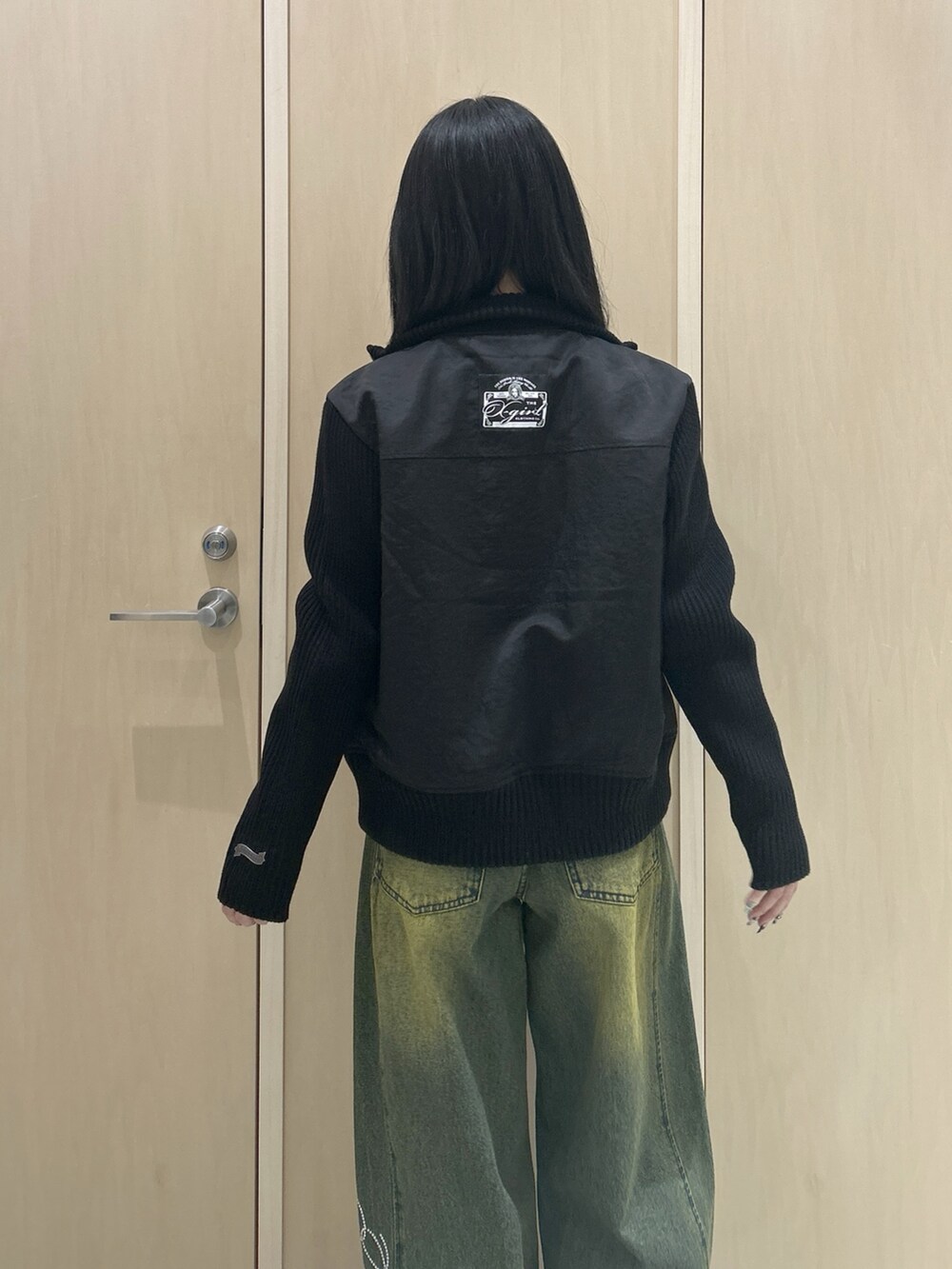 グレー系のTシャツ/カットソー、ブラック系のブルゾン、ブラック系のハンドバッグを着用したレディースの冬コーディネートの5枚目の写真